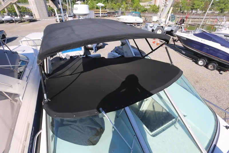 Slide: The Image of 2000 Chaparral Signature 300 boat with black canopy in a marina setting. - 67