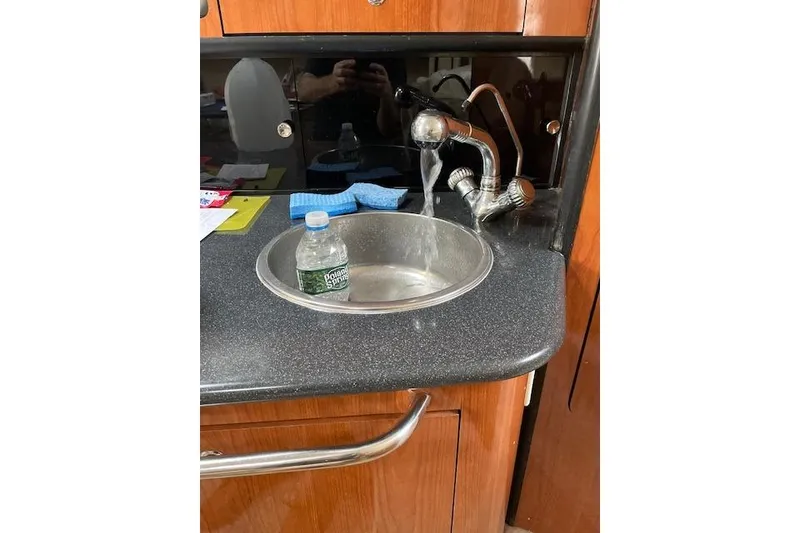 Slide: The Image of Chaparral Signature 300 yacht kitchen sink with running water and countertop items. - 8