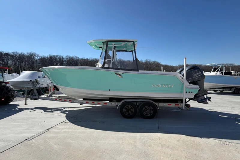 Slide: The Image of 2020 Blackfin 242 CC boat on trailer, mint green hull, parked outdoors. - 11