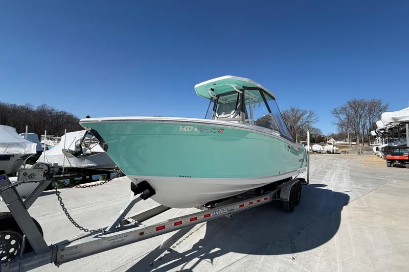 Slide: The Image of 2020 Blackfin 242 CC boat on trailer under clear blue sky. - 13