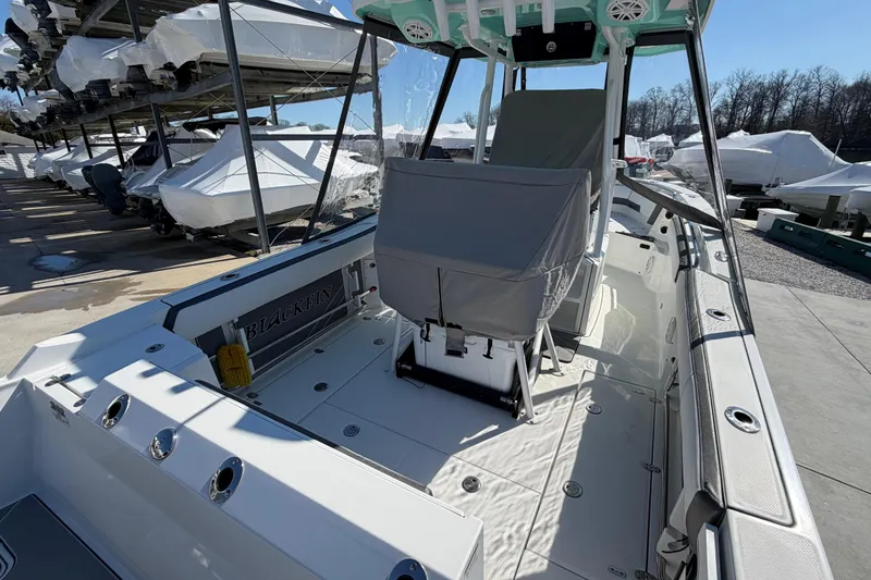 Slide: The Image of 2020 Blackfin 242 CC boat interior with covered seating, docked among other boats. - 14