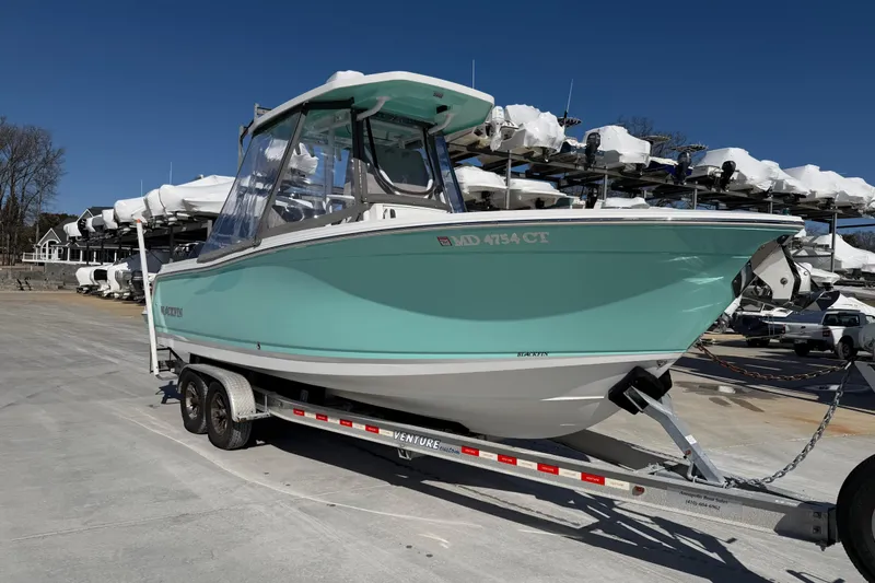 Slide: The Image of 2020 Blackfin 242 CC boat on trailer, mint green hull, parked outdoors. - 2