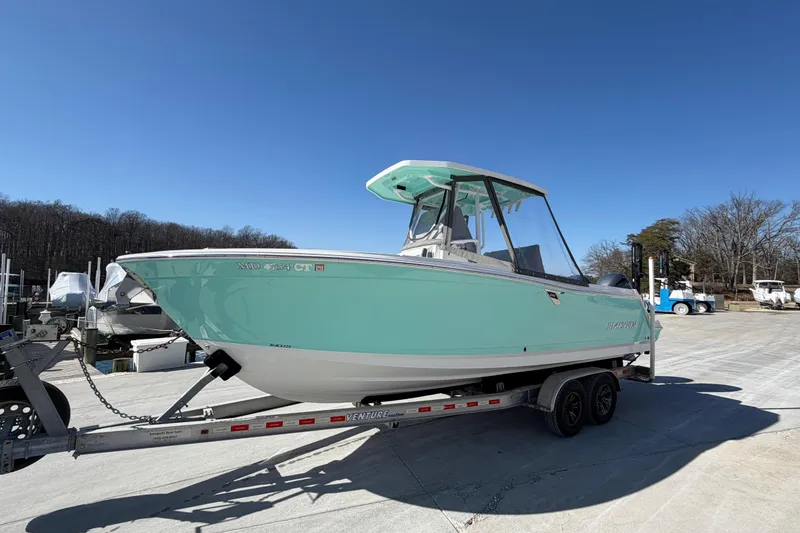 Slide: The Image of 2020 Blackfin 242 CC boat on trailer under clear blue sky. - 27