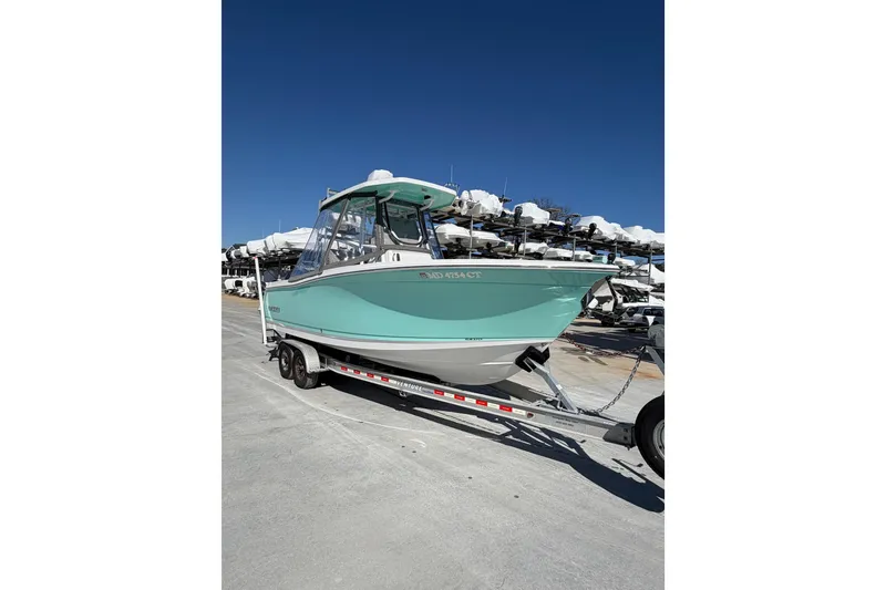 Slide: The Image of 2020 Blackfin 242 CC boat on trailer under clear blue sky. - 4