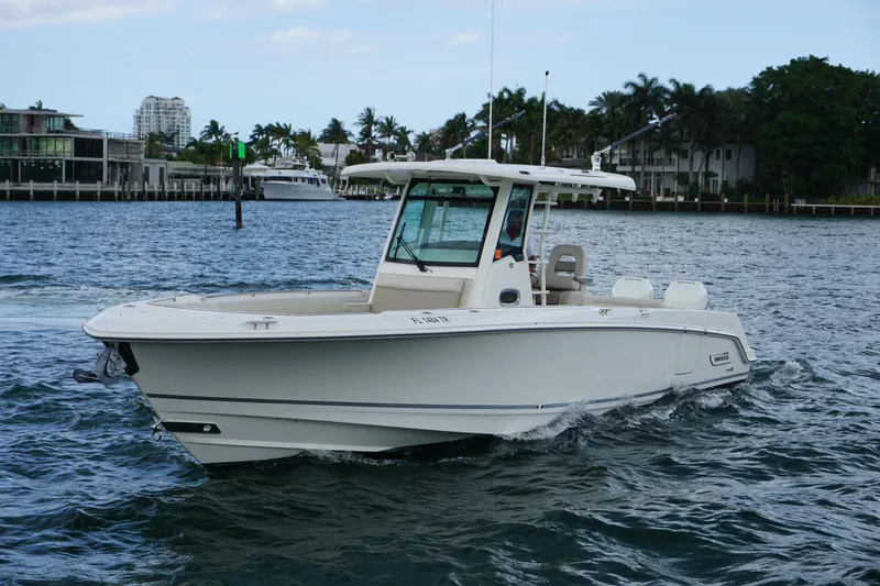 Slide: The Image of 2018 Boston Whaler 330 Outrage cruising on a scenic waterfront. - 10