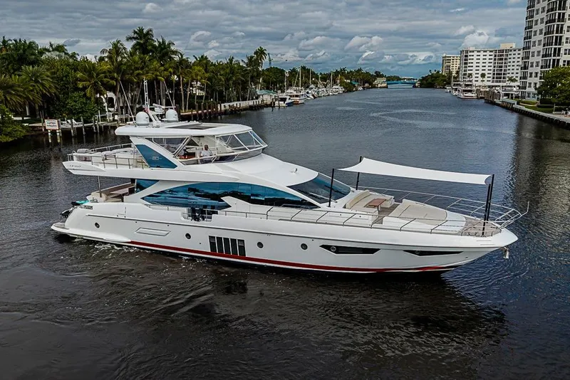 The Image of Luxury 2017 Azimut 80 yacht cruising on a scenic waterway with lush surroundings. - 0