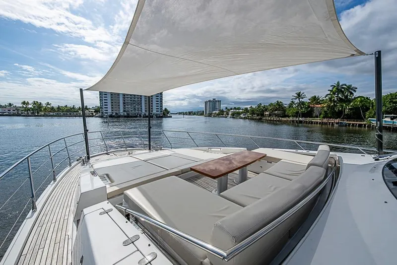 Slide: The Image of Luxurious 2017 Azimut 80 yacht deck with seating, table, and sunshade on a scenic waterway. - 10