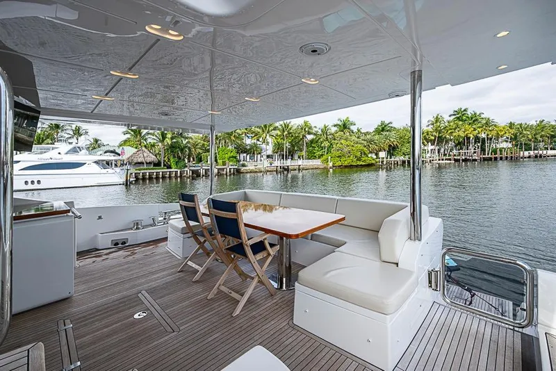 Slide: The Image of Luxurious 2017 Azimut 80 yacht deck with seating, overlooking serene waterfront and palm trees. - 13