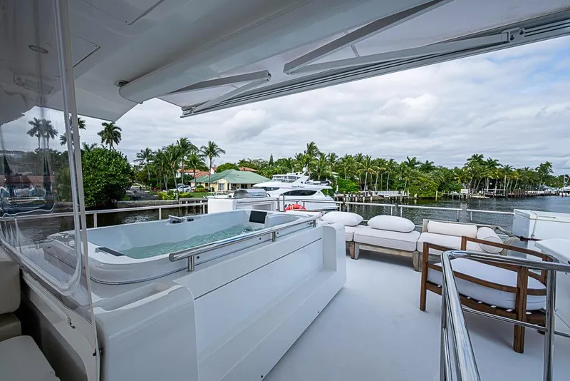 Slide: The Image of Luxurious 2017 Azimut 80 yacht deck with jacuzzi and seating, overlooking a serene waterfront. - 29