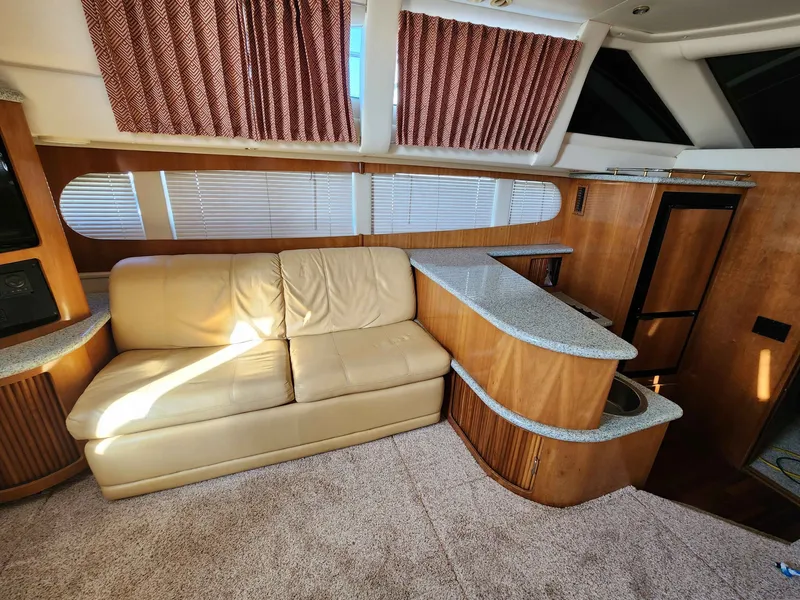 Slide: The Image of Interior of a 2001 Carver 396 yacht with beige sofa and wooden furnishings. - 34