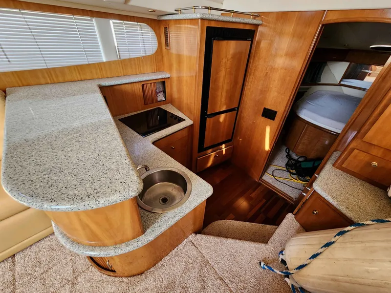 Slide: The Image of Interior of 2001 Carver 396 yacht featuring kitchen and sleeping area. - 40