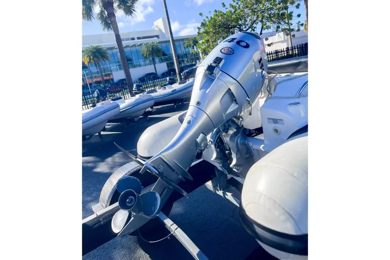 Slide: The Image of 2021 Walker Bay Generation 340 boat with powerful outboard motor in sunny marina setting. - 2