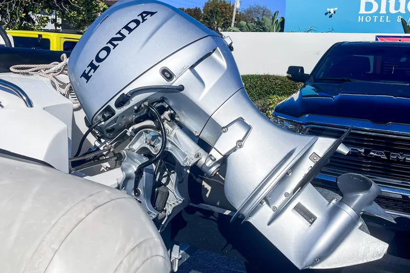 Slide: The Image of Walker Bay Generation 340 boat with Honda outboard motor, 2021 model, parked near a hotel. - 3