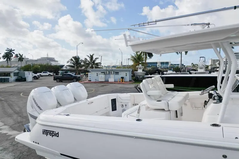 Slide: The Image of 2022 Intrepid 345 Nomad FE boat with twin Mercury engines docked at a marina. - 10