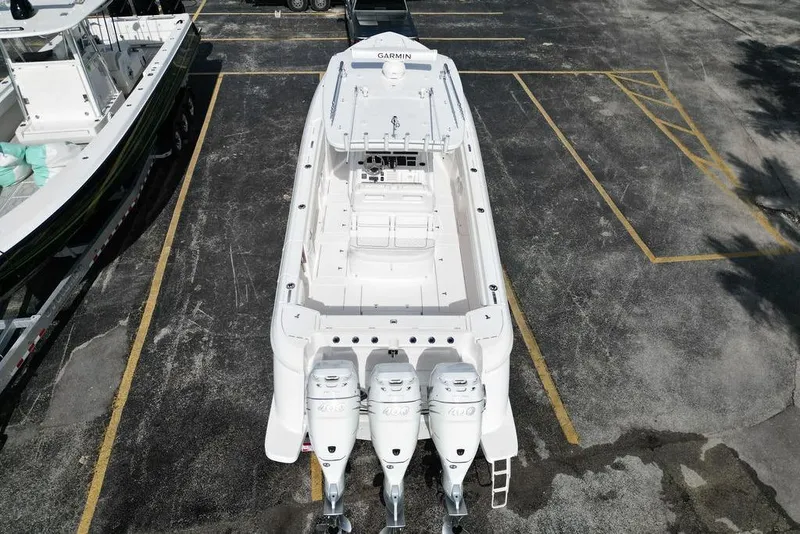 Slide: The Image of 2022 Intrepid 345 Nomad FE boat with triple engines in a parking lot. - 14