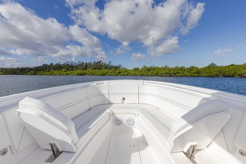 Slide: The Image of Manufacturer Provided Image: 2022 Intrepid 345 Nomad FE boat with white seating, on a calm water body. - 15