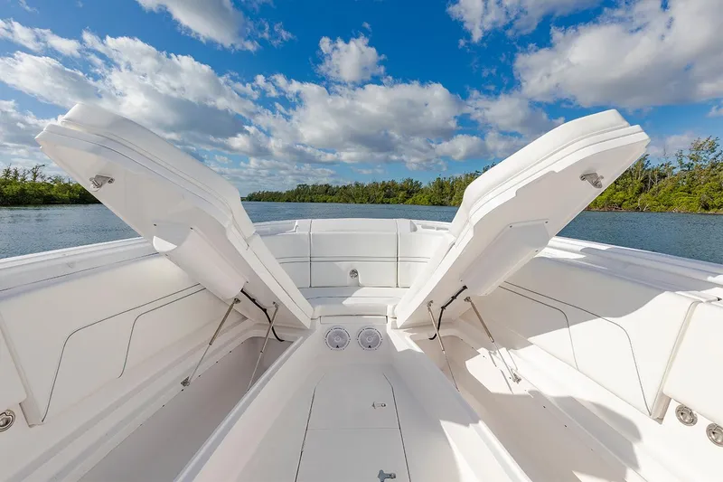 Slide: The Image of Manufacturer Provided Image: 2022 Intrepid 345 Nomad FE boat with open storage compartments on a sunny day. - 16