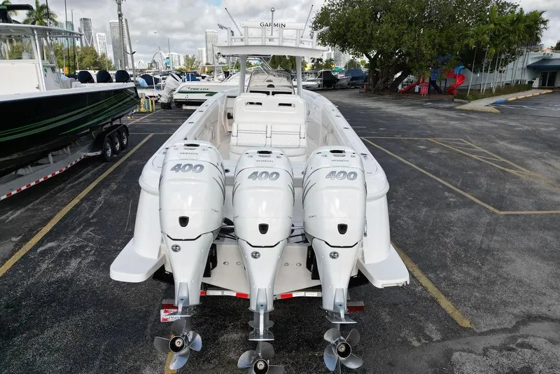 Slide: The Image of 2022 Intrepid 345 Nomad FE boat with triple 400 horsepower engines, parked outdoors. - 2