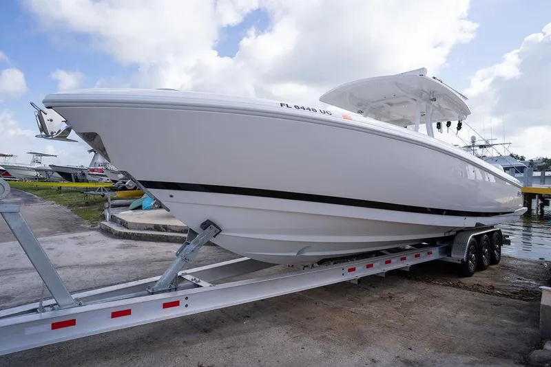 Slide: The Image of 2022 Intrepid 345 Nomad FE boat on trailer, ready for launch under a cloudy sky. - 20