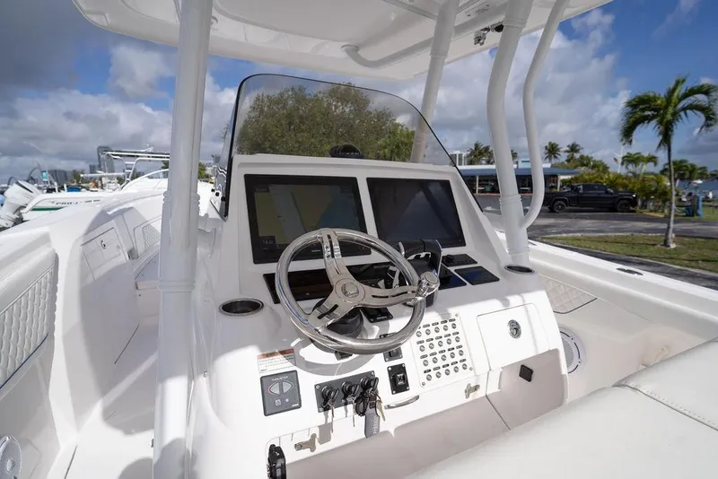 Slide: The Image of 2022 Intrepid 345 Nomad FE boat cockpit with steering wheel and navigation screens. - 22