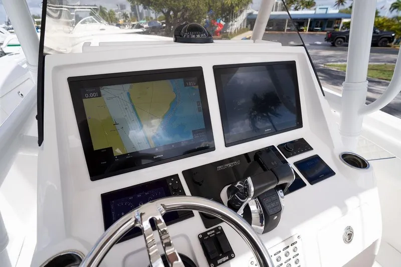 Slide: The Image of 2022 Intrepid 345 Nomad FE boat dashboard with dual Garmin displays and controls. - 24