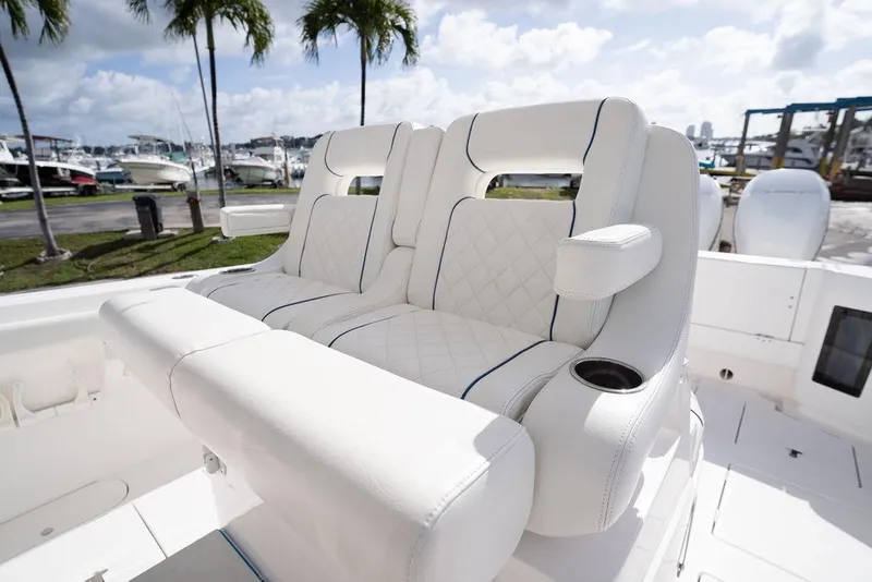 Slide: The Image of Luxurious seating on 2022 Intrepid 345 Nomad FE boat, featuring white upholstery and cup holders. - 26
