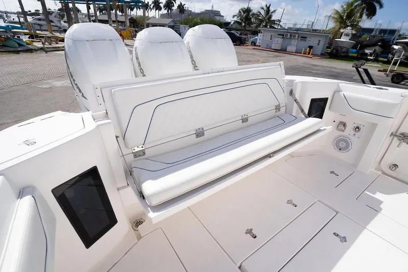 Slide: The Image of 2022 Intrepid 345 Nomad FE boat with seating and triple engines at a marina. - 29