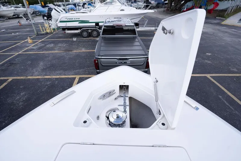 Slide: The Image of 2022 Intrepid 345 Nomad FE boat with open anchor compartment in a parking lot. - 31
