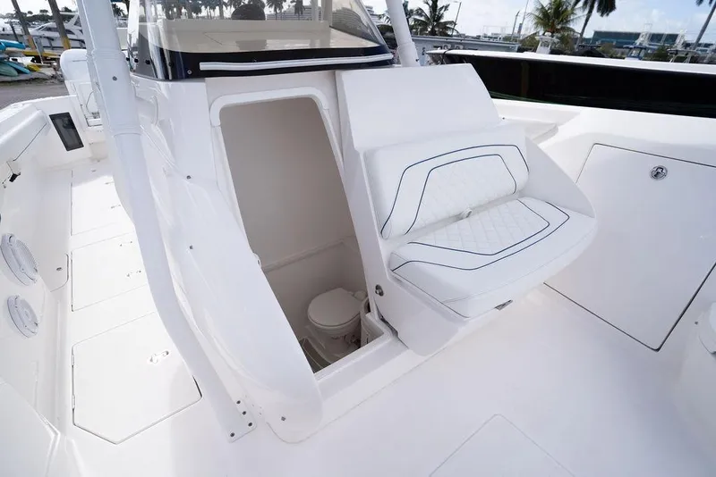 Slide: The Image of 2022 Intrepid 345 Nomad FE boat interior with seating and hidden toilet compartment. - 36