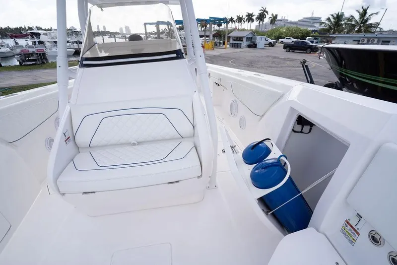 Slide: The Image of 2022 Intrepid 345 Nomad FE boat interior with white seating and storage compartment. - 37