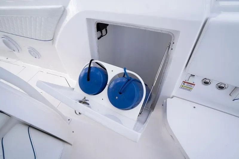Slide: The Image of 2022 Intrepid 345 Nomad FE boat storage compartment with blue fenders and white interior. - 38