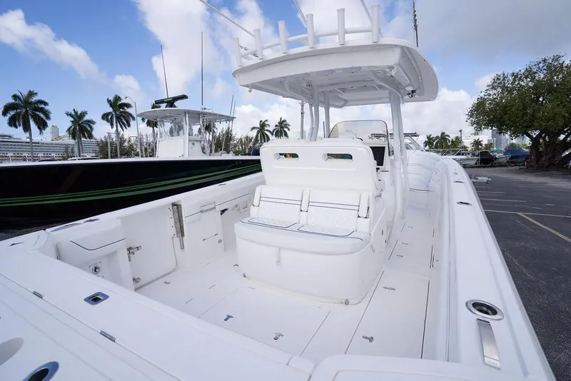 Slide: The Image of 2022 Intrepid 345 Nomad FE boat with spacious deck and seating, docked under a blue sky. - 41