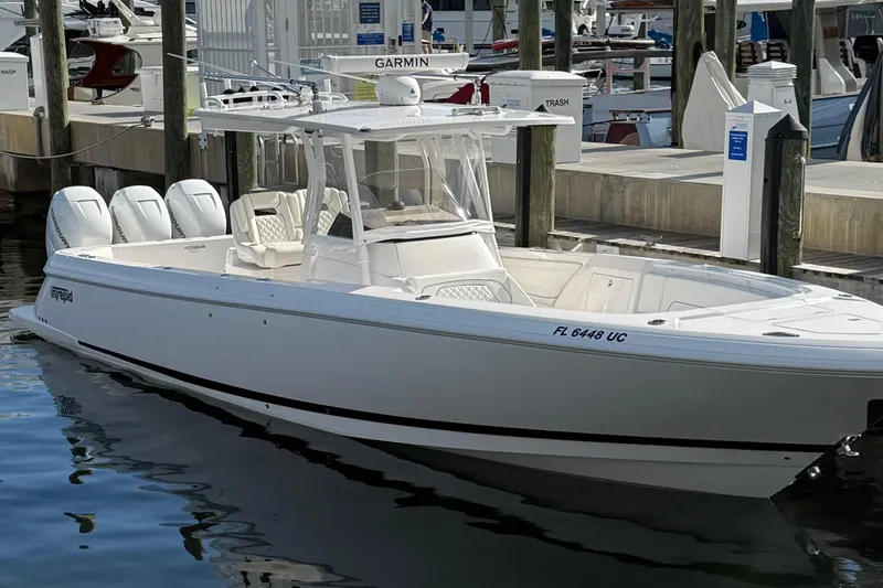 Slide: The Image of 2022 Intrepid 345 Nomad FE boat docked with triple outboard engines. - 44