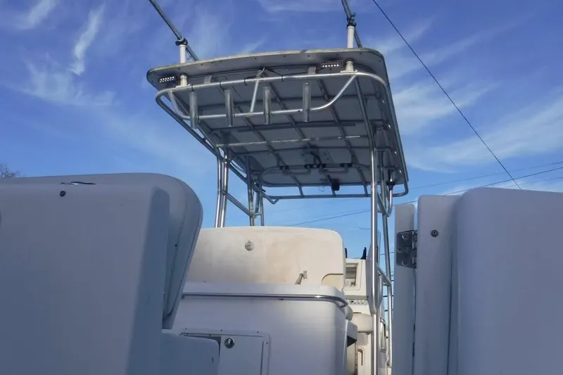 Slide: The Image of 2006 PROLINE 31 Center Console boat with trailer, featuring a sturdy T-top under a clear blue sky. - 8