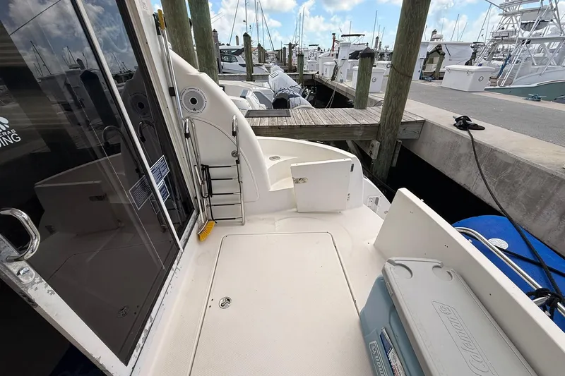 Slide: The Image of 2008 Meridian 341 Sedan yacht docked at marina, featuring spacious deck and ladder access. - 12