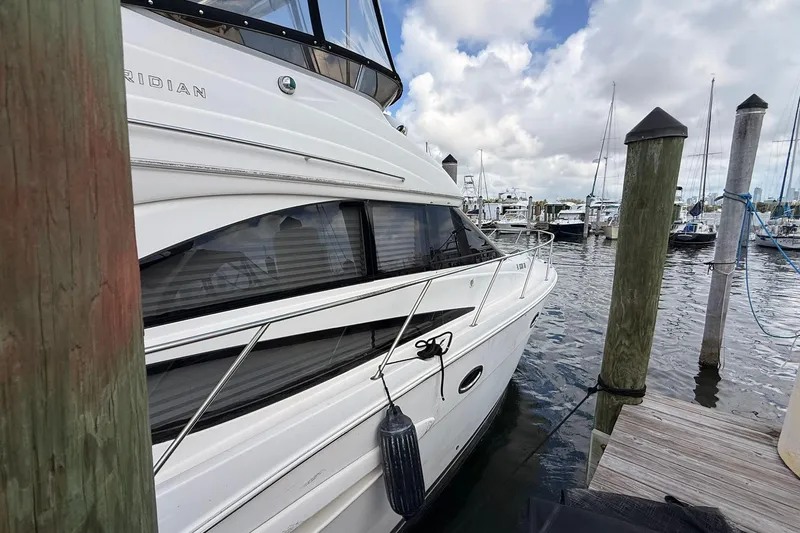 Slide: The Image of 2008 Meridian 341 Sedan yacht docked at a marina under cloudy skies. - 2