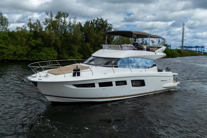 Slide: The Image of 2012 Prestige Flybridge yacht cruising on a scenic waterway under cloudy skies. - 10