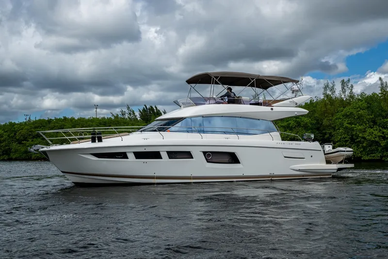 Slide: The Image of 2012 Prestige Flybridge yacht cruising on a calm river under cloudy skies. - 13