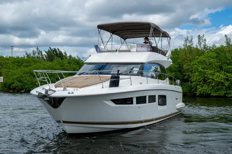 Slide: The Image of 2012 Prestige Flybridge yacht cruising on a river with lush greenery. - 15