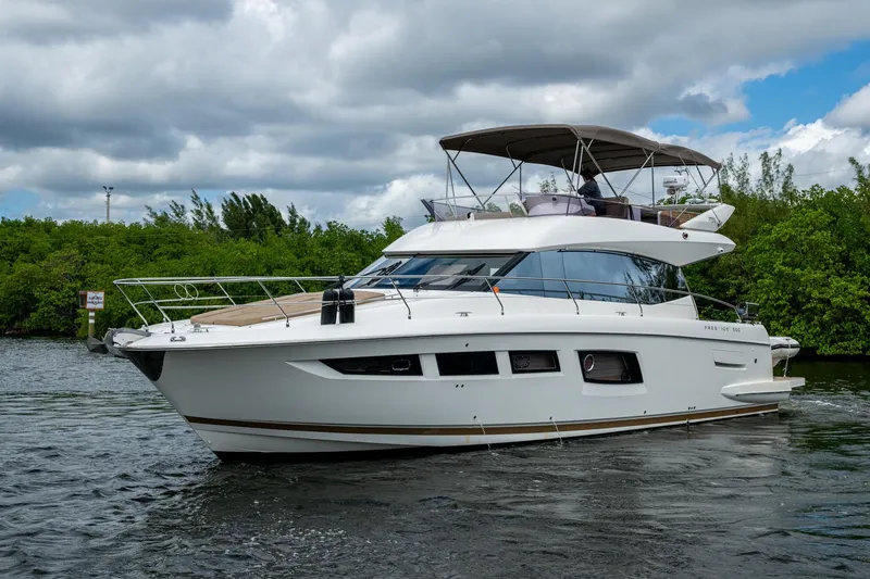 Slide: The Image of 2012 Prestige Flybridge yacht cruising on a scenic waterway under cloudy skies. - 16