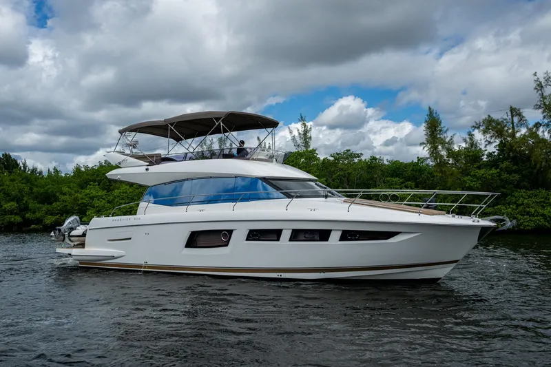 Slide: The Image of 2012 Prestige Flybridge yacht cruising on a scenic waterway under a cloudy sky. - 18