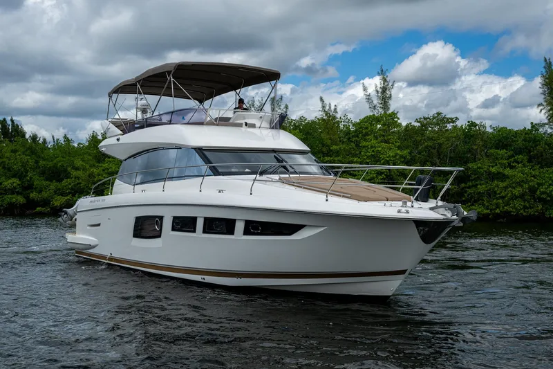 Slide: The Image of 2012 Prestige Flybridge yacht cruising on a scenic waterway under cloudy skies. - 19