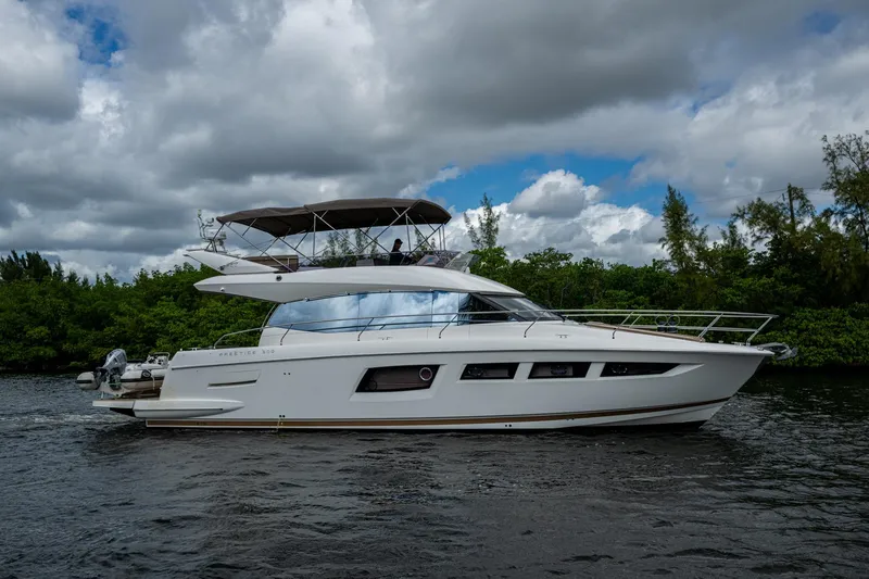 Slide: The Image of 2012 Prestige Flybridge yacht cruising on a scenic waterway under cloudy skies. - 20