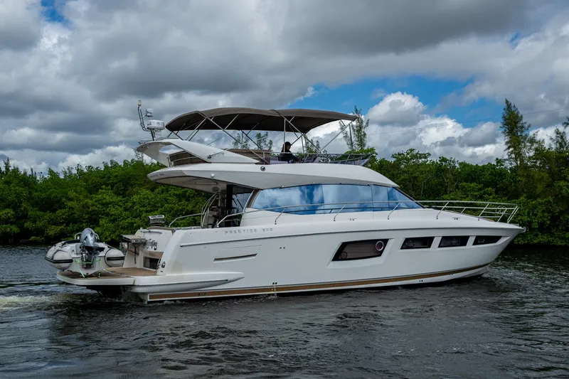 Slide: The Image of 2012 Prestige Flybridge yacht cruising on a river under cloudy skies. - 21