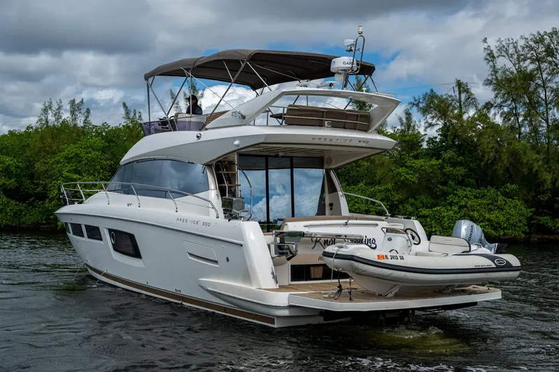 Slide: The Image of 2012 Prestige Flybridge yacht cruising on a scenic waterway with lush greenery. - 25