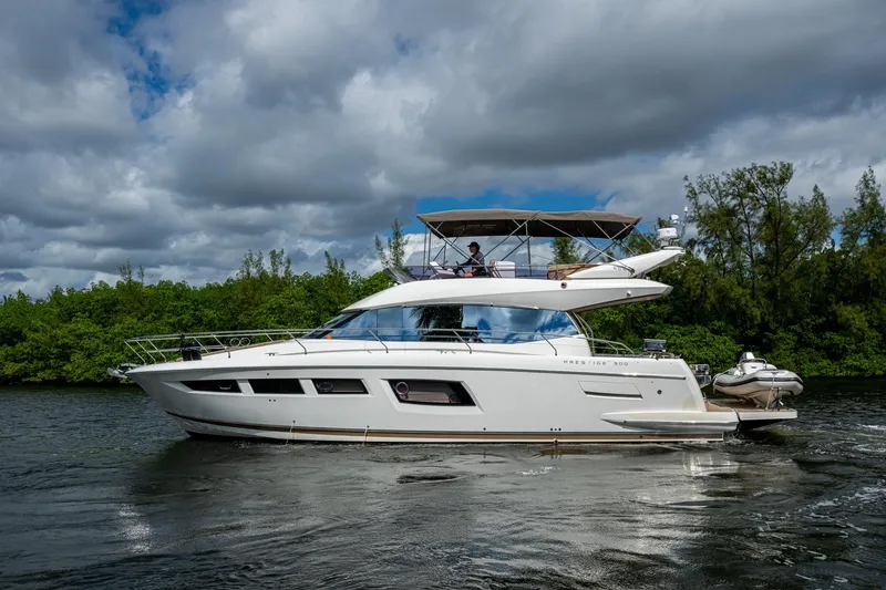 Slide: The Image of 2012 Prestige Flybridge yacht cruising on a scenic waterway with lush greenery. - 29
