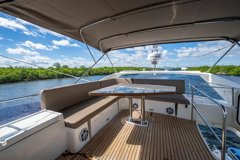 Slide: The Image of 2012 Prestige Flybridge yacht deck with seating, table, and scenic water view. - 33