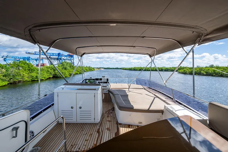 Slide: The Image of 2012 Prestige Flybridge yacht with spacious deck, canopy, and scenic river view. - 34