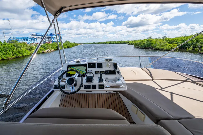 Slide: The Image of 2012 Prestige Flybridge yacht helm with scenic river view and clear skies. - 37