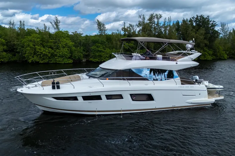 Slide: The Image of 2012 Prestige Flybridge yacht cruising on a serene river with lush greenery. - 4